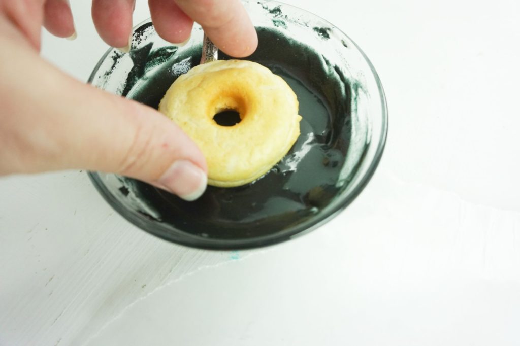 dipping donuts into black icing